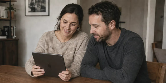 Couple reviewing photos together on a tablet while choosing an image for custom wall art.