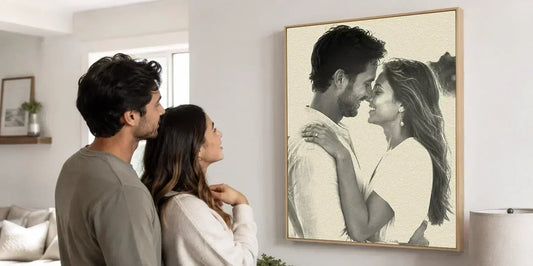 Couple admiring a framed custom anniversary portrait in a neutral home interior.
